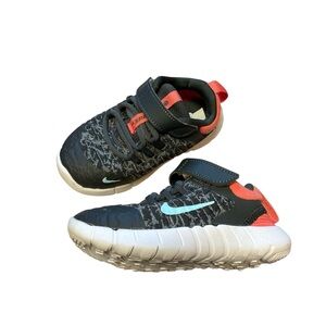 Nike Kids Black and White Sneakers with Orange Accents.